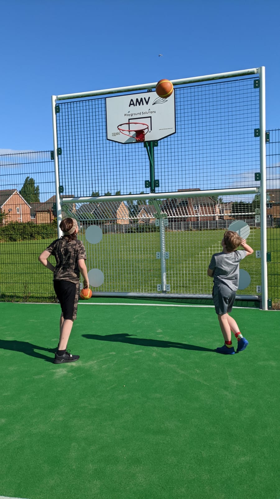 A boy and a girl are playing basketball on a court.