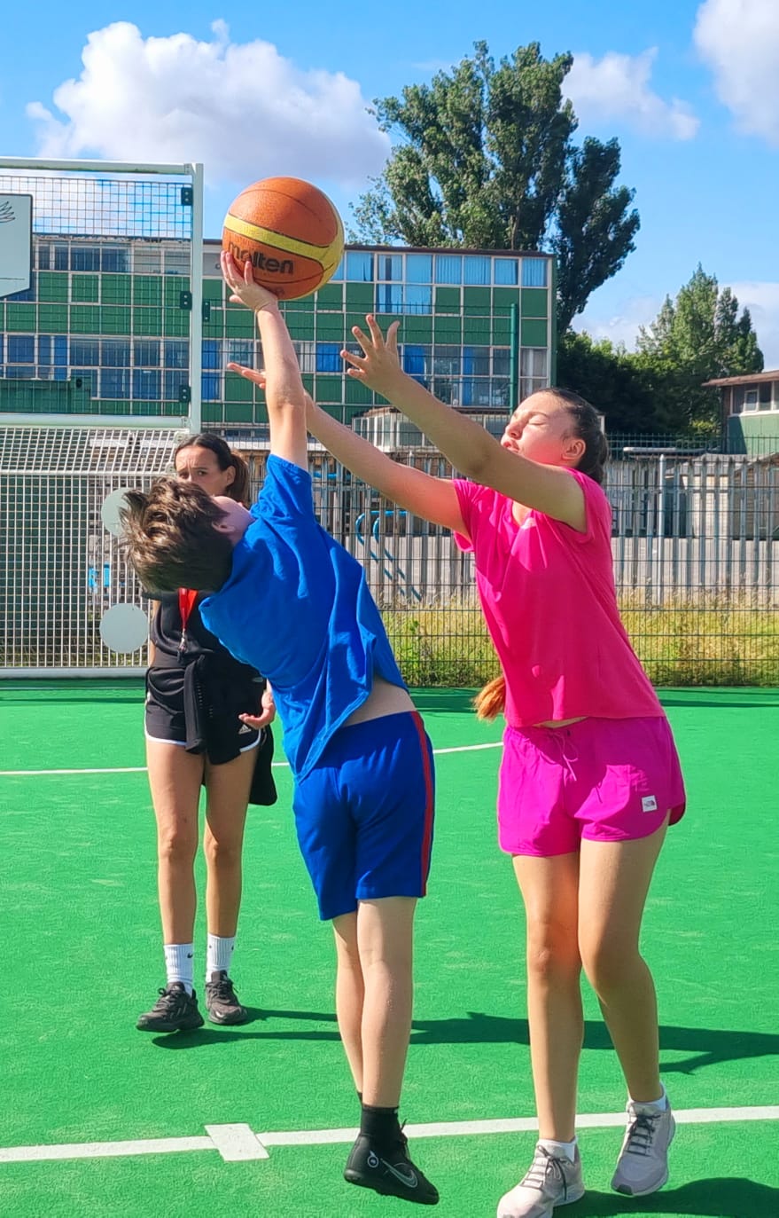 A group of children are playing basketball on a field.