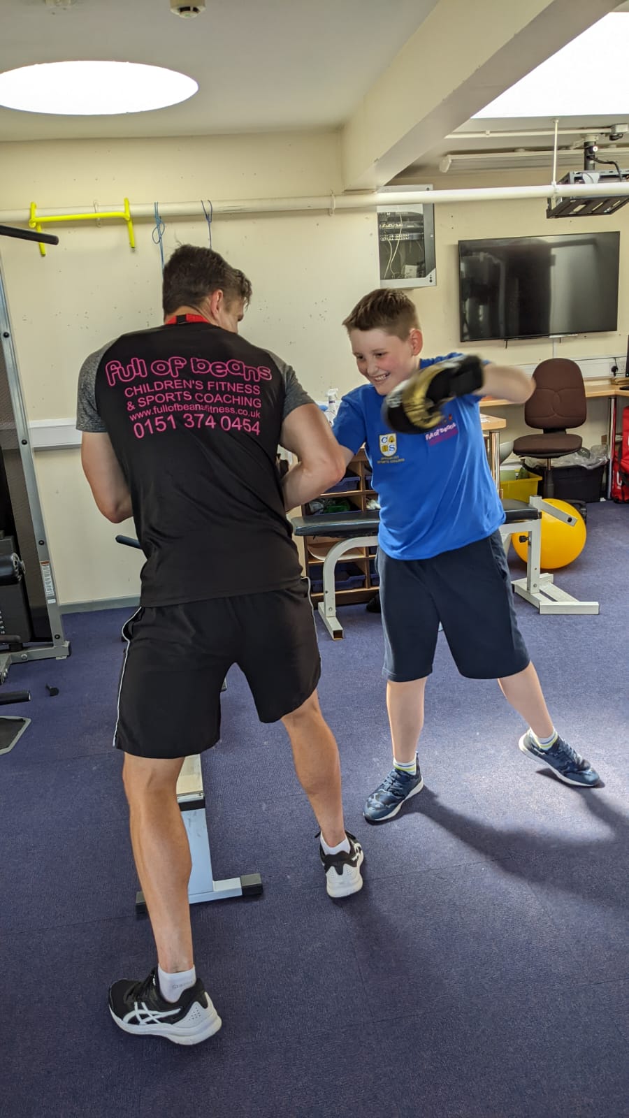 Two young men are boxing in a gym.