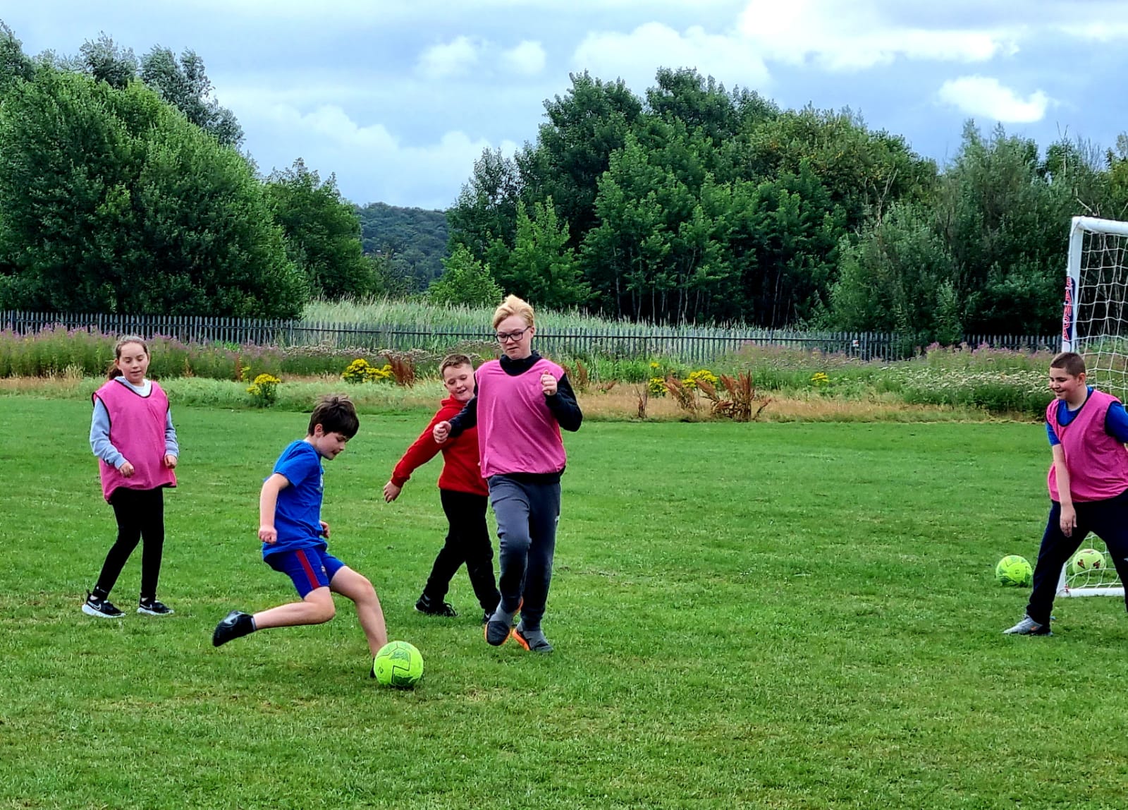 A group of children are playing soccer on a field.