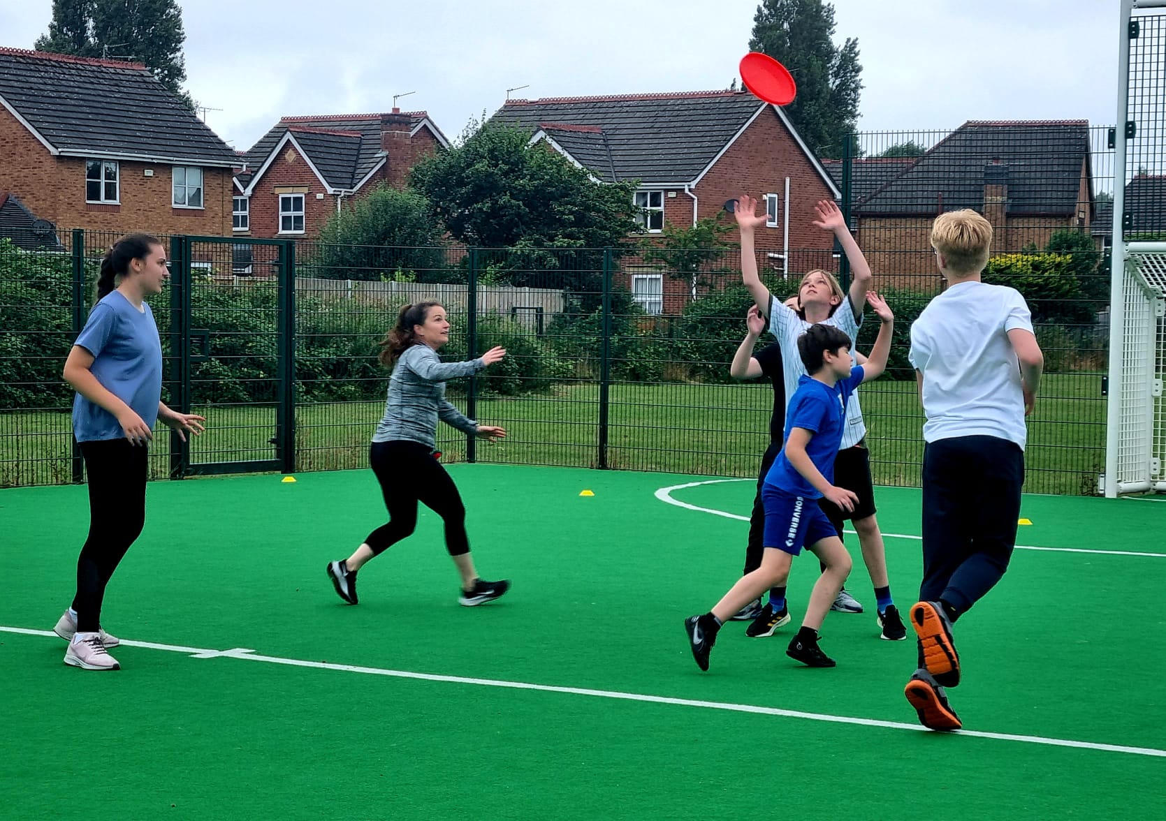A group of children are playing frisbee on a green field.