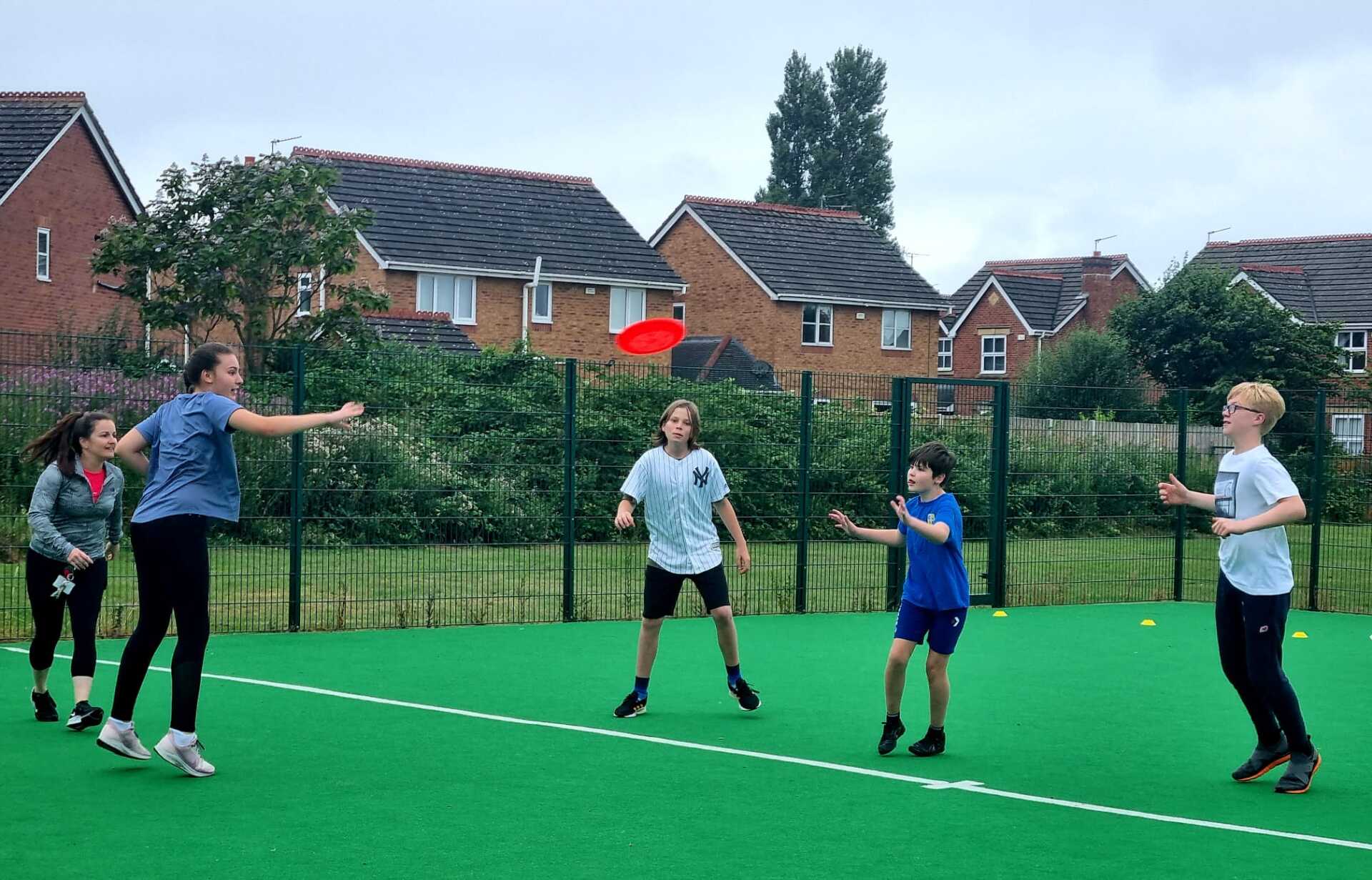 A group of children are playing frisbee on a field.