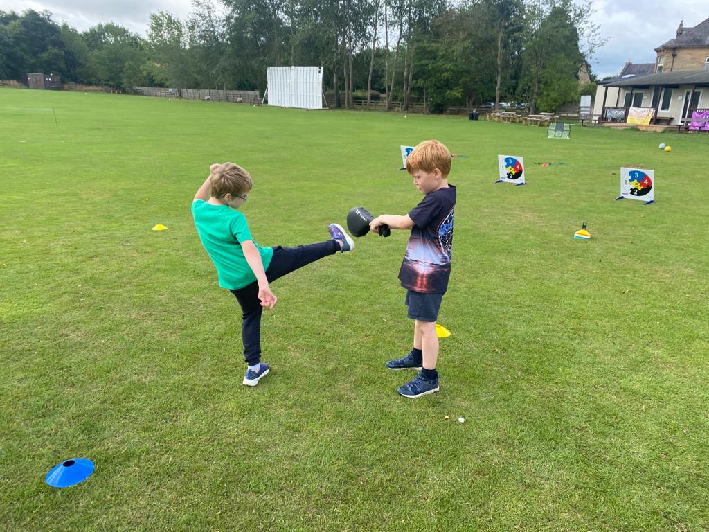 Two young boys are playing soccer in a field.