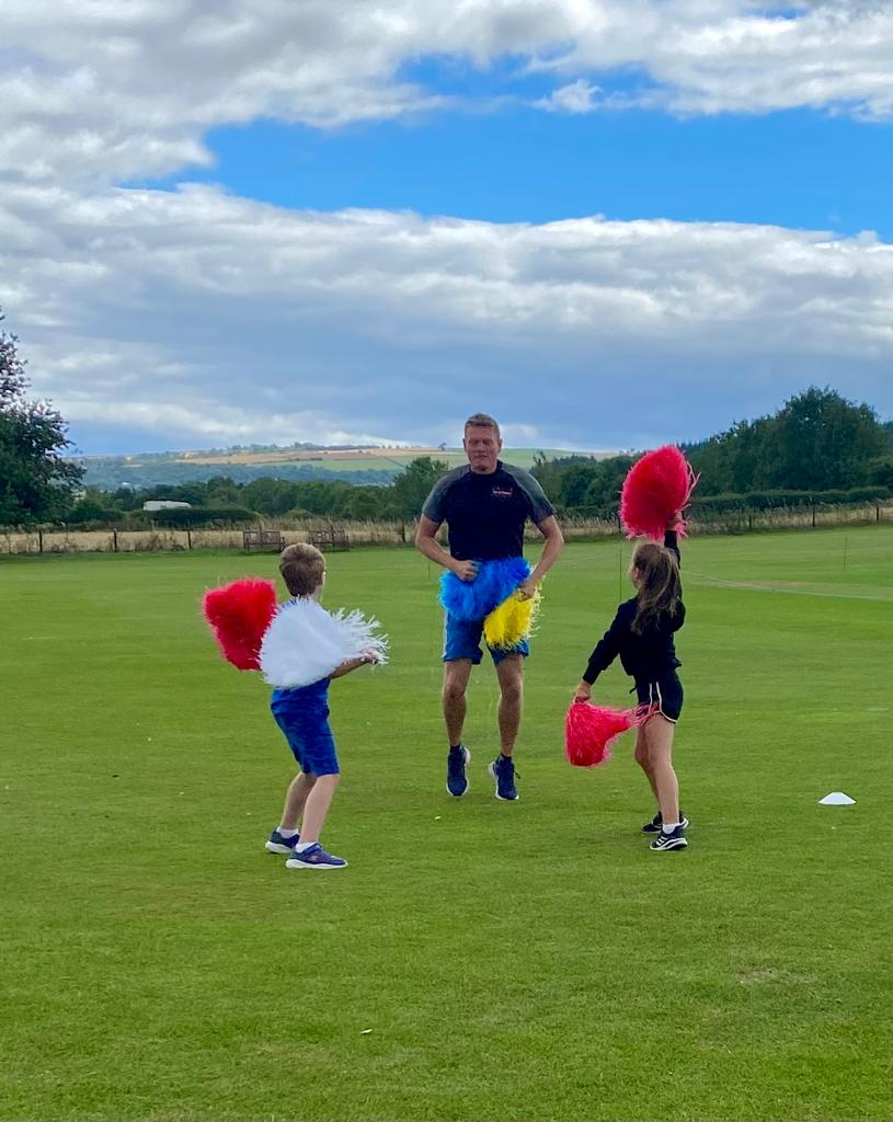 A man and two children are playing in a field.
