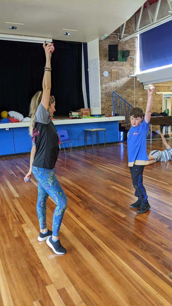 A woman and a boy are dancing in a dance studio.