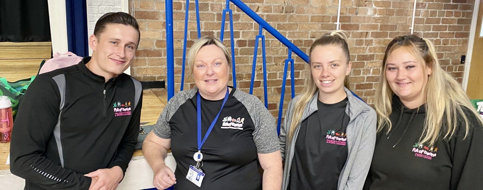 A group of people standing next to each other in front of a staircase.