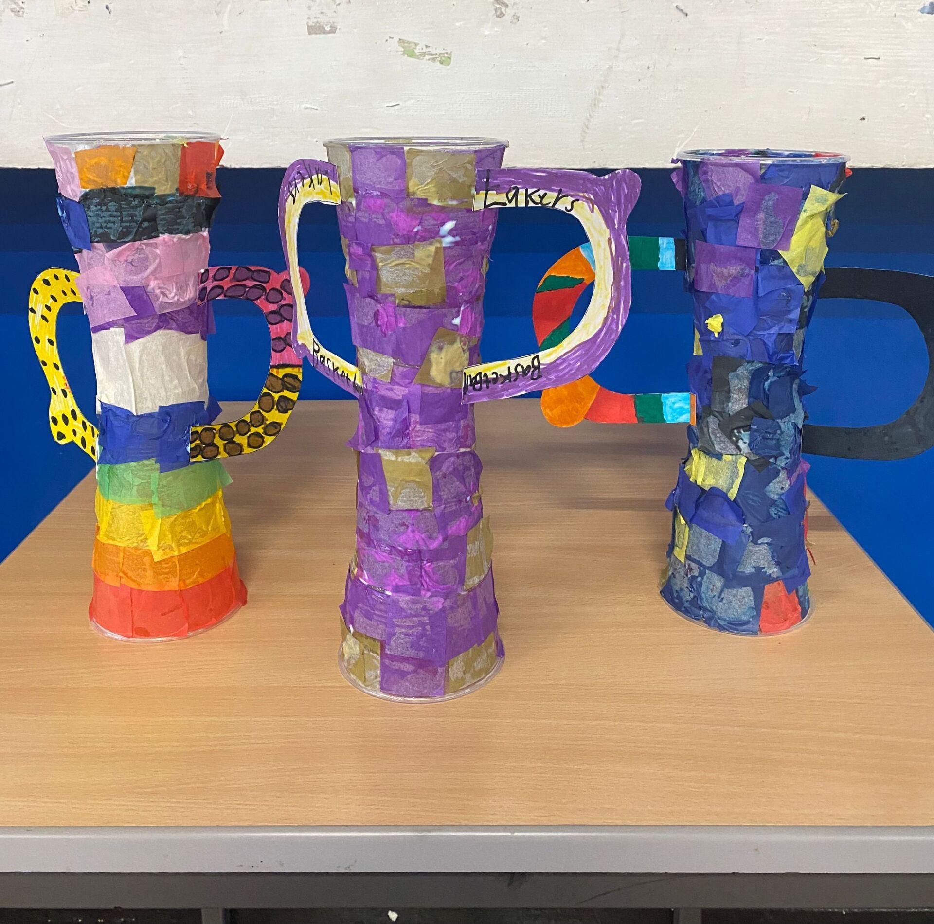 Three purple vases are sitting on a wooden table