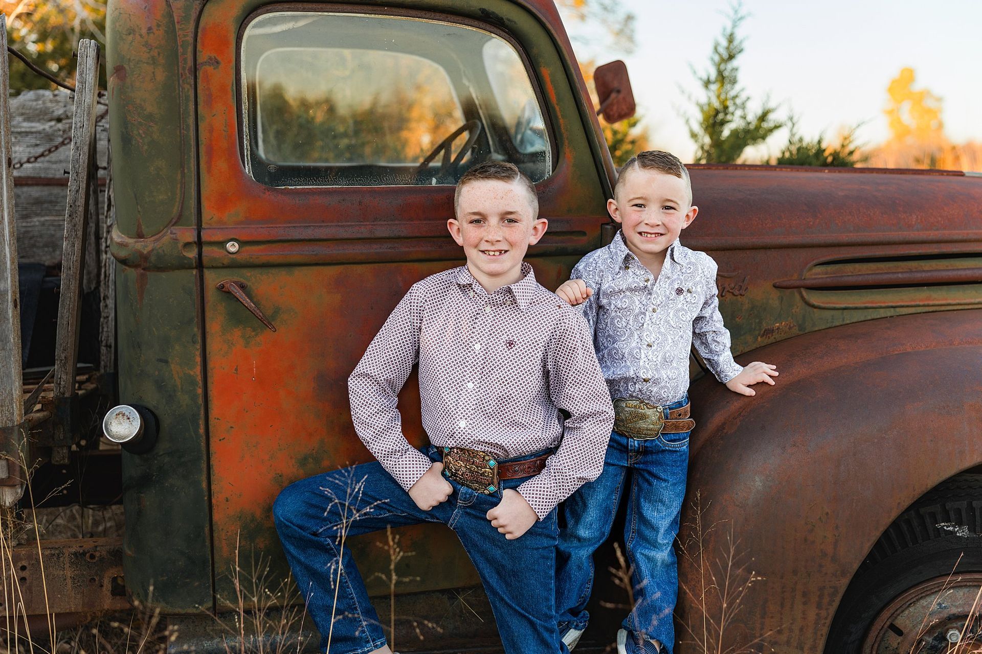 two brothers laughing on vintage pickup at sunset farm mini session in Burrton KS by Sara McMillian
