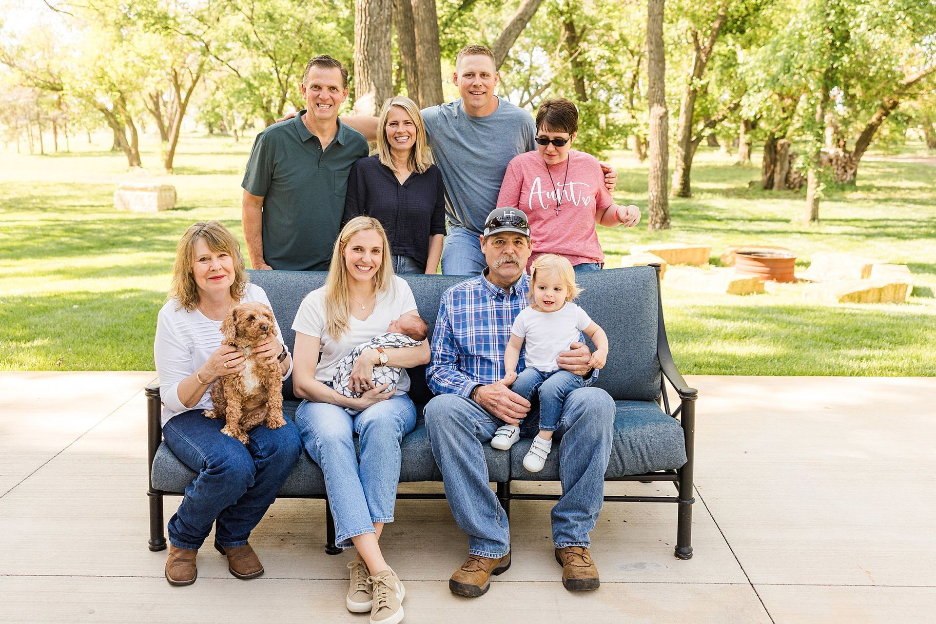 Extended family cuddling newborn during relaxed outdoor session Burrton KS Sara McMillian Photography