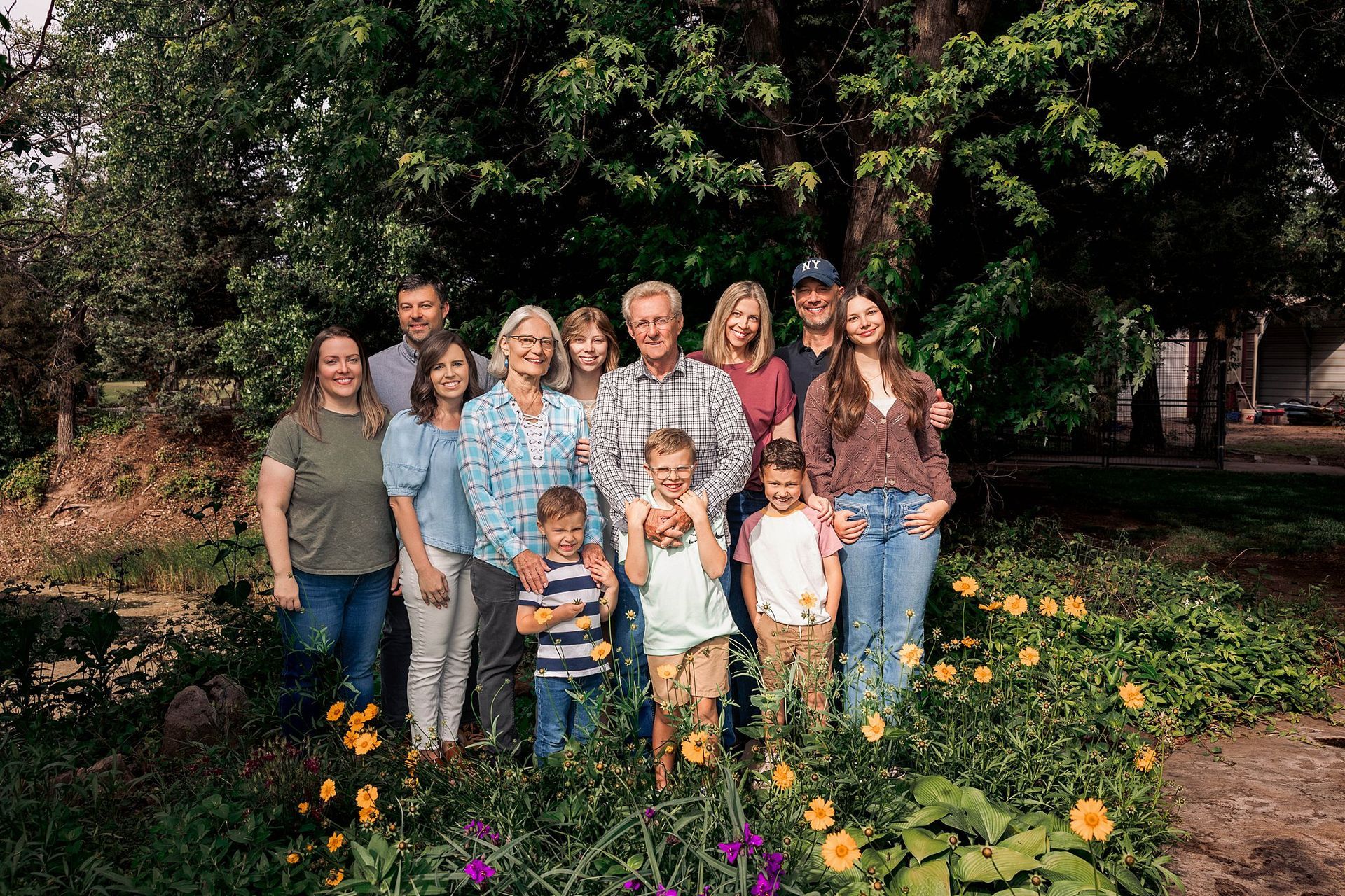 Extended family laughing among blooming garden at grandma's house in soft morning light Burrton KS Sara McMillian