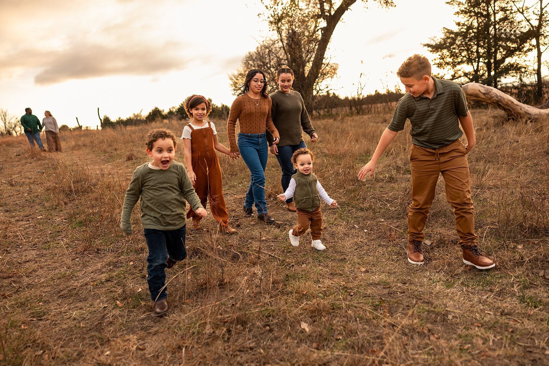 
Playful unposed family laughing as they walk in the pasture with golden light during farm mini session Burrton KS Sara McMillian Photography