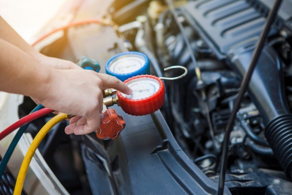 A Mechanic Using Gauges to Check a Car Air Conditioning System — Woden Automotive Services in Garran, ACT