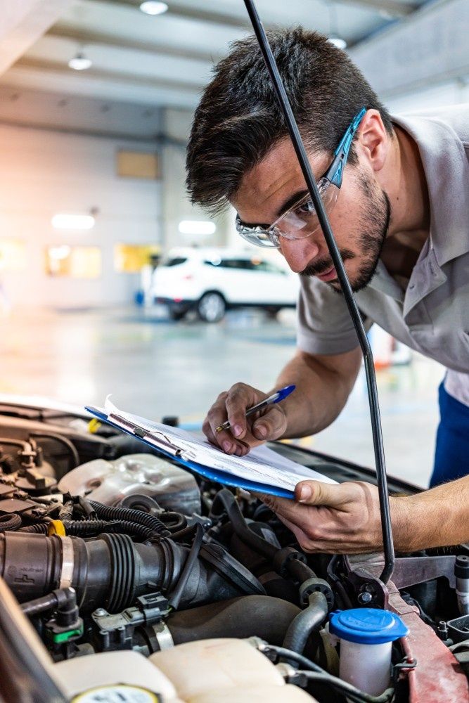 A Mechanic in Safety Glasses Inspects Engine — Woden Automotive Services in Phillip, ACT
