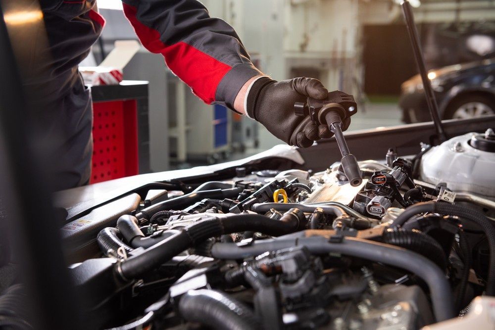A Mechanic in Gloves Working on A Car Engine — Woden Automotive Services in Garran, ACT