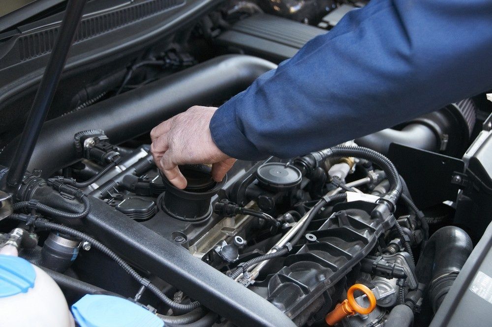 A Mechanic Checking an Engine Oil in A Car — Woden Automotive Services in Mawson, ACT