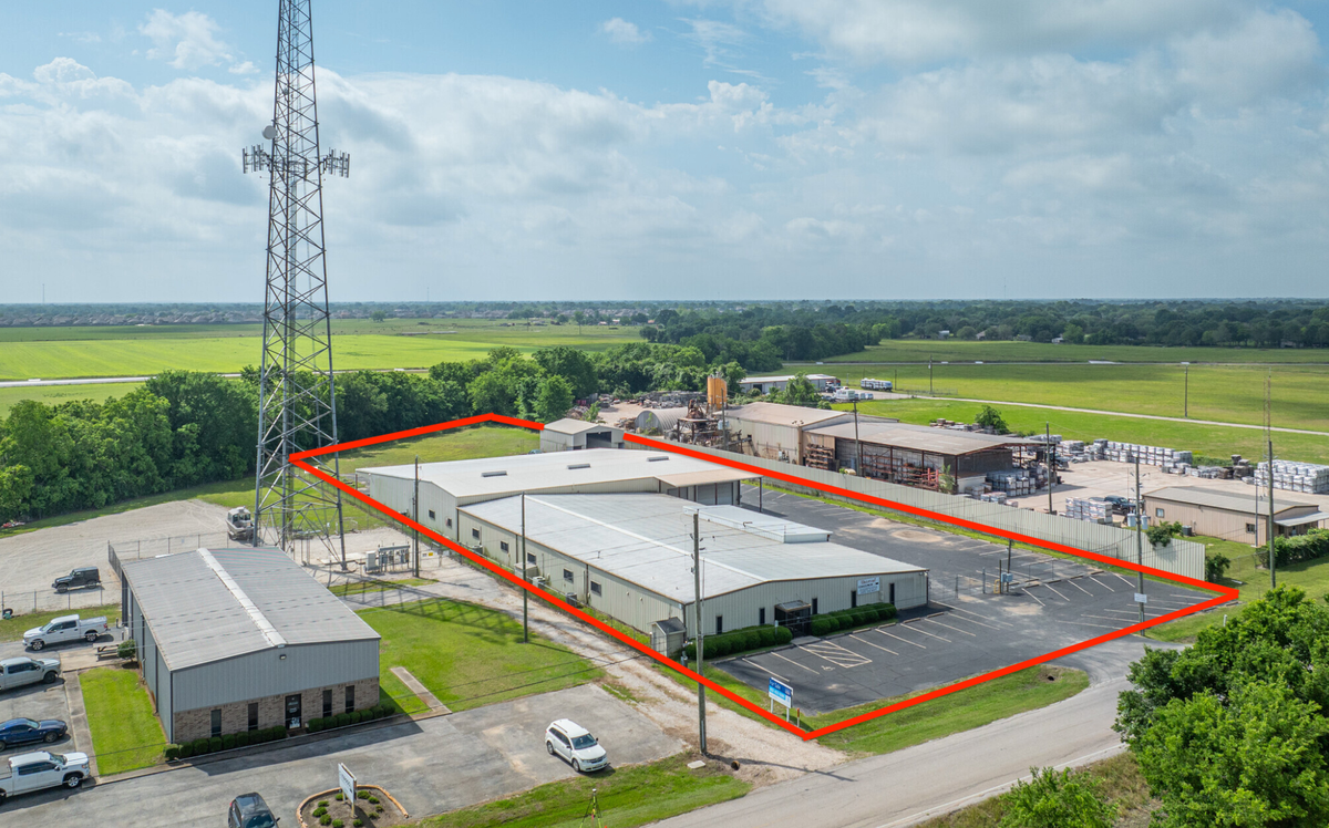 An aerial view of a warehouse with a red line drawn around it.
