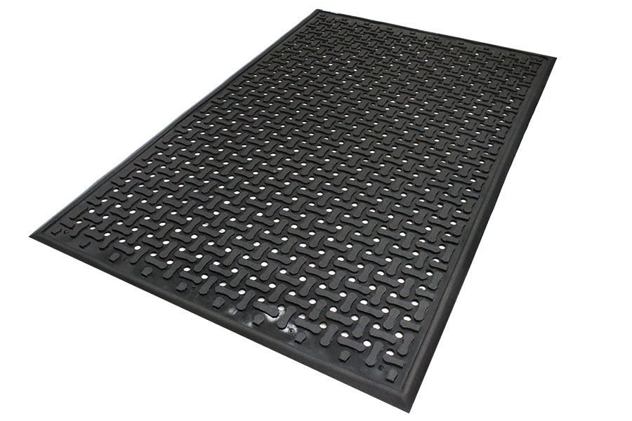 A black mat with holes in it is laying on a white surface.