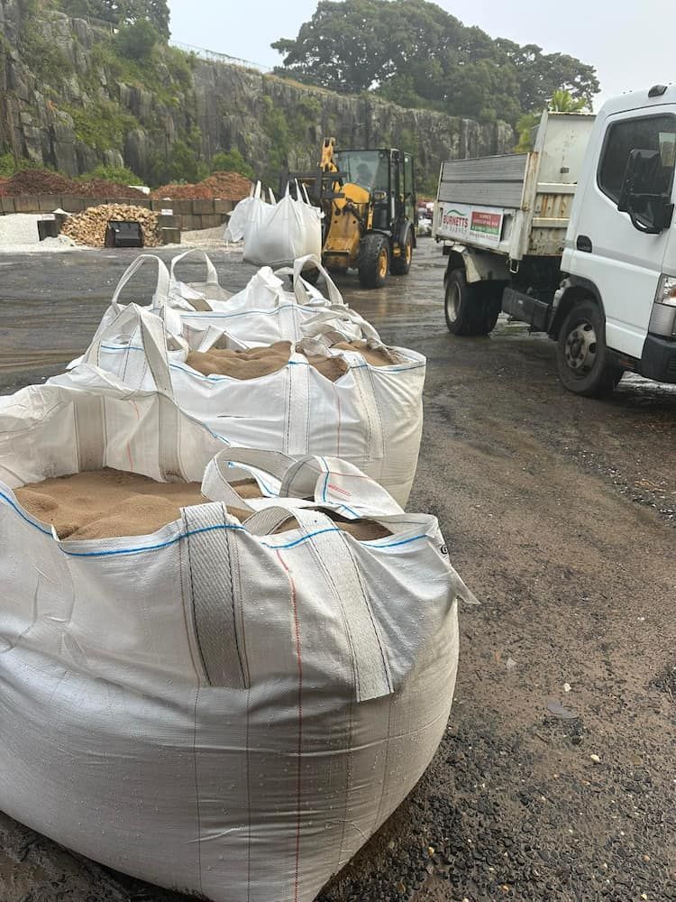 A Truck Is Carrying Bags Of Sand In A Parking Lot — Burnetts On Barney in Shellharbour, NSW