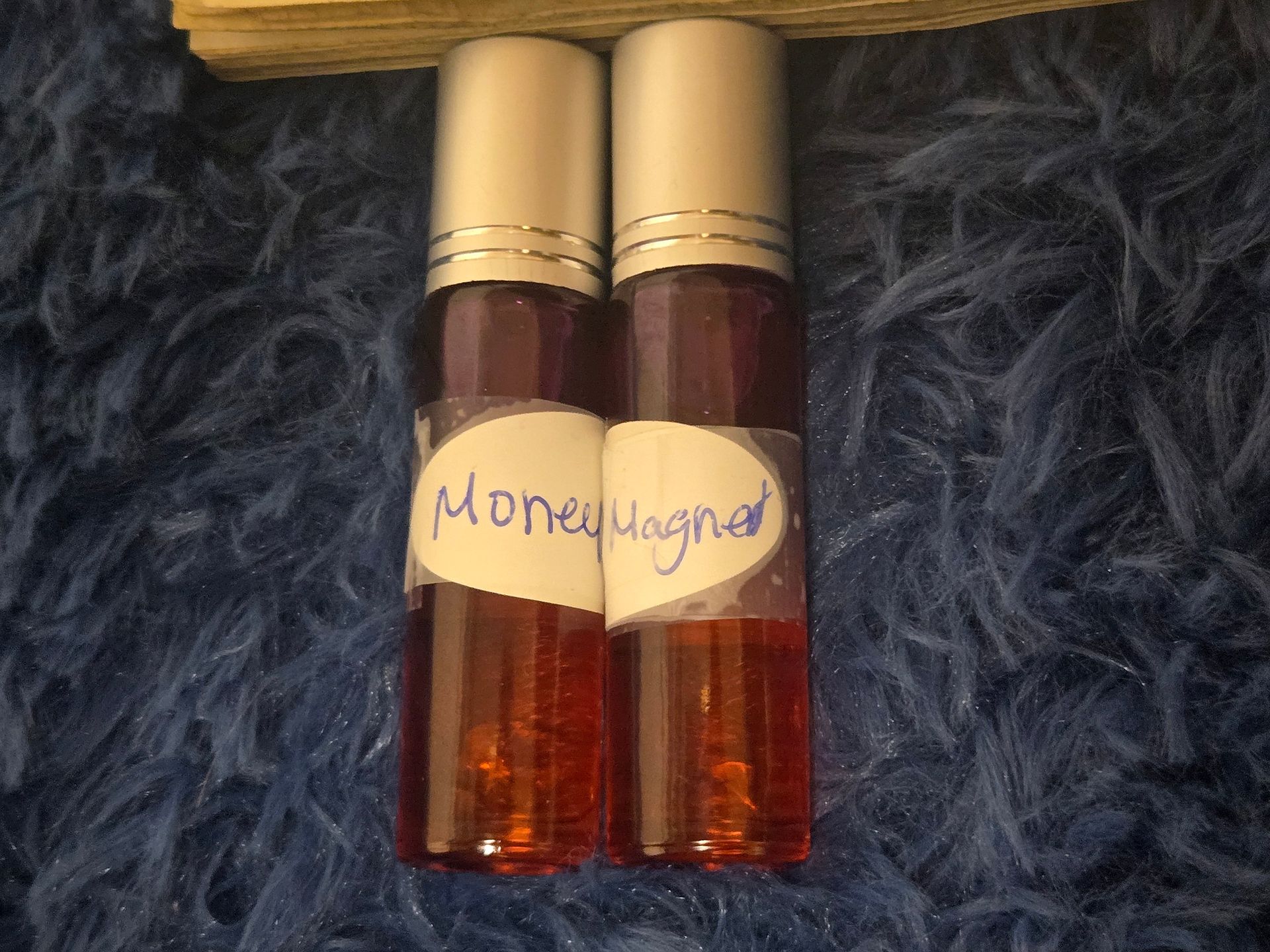 Two bottles of montemagno perfume are sitting on a blue blanket
