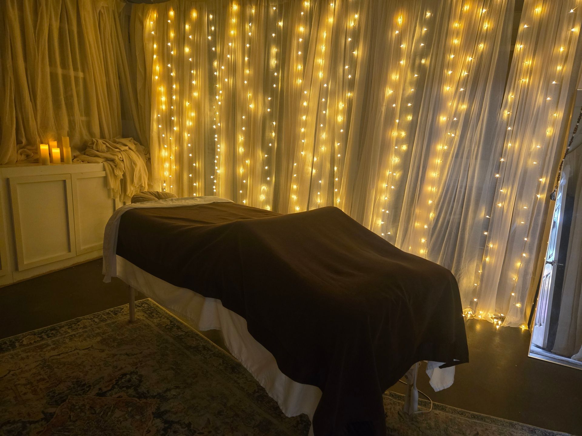 A massage table in a room with lights on the wall