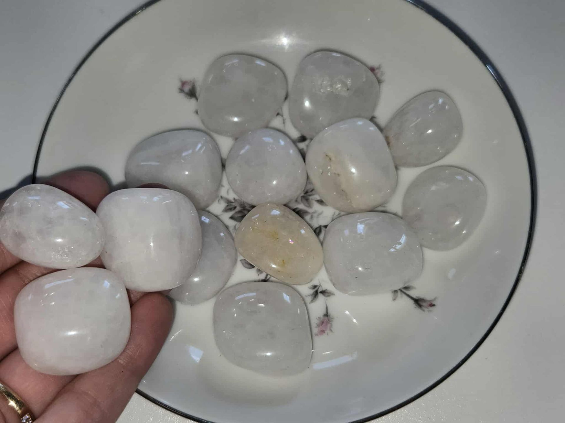 White tumbled stones in a decorative floral dish.