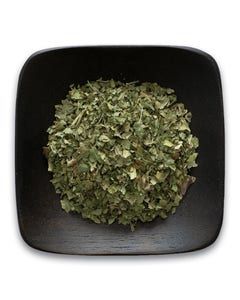 A black bowl filled with dried herbs on a white background.