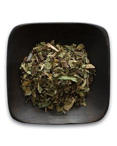 A wooden bowl filled with dried herbs on a white background.
