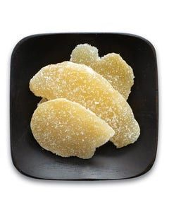 A black plate topped with slices of candy on a white background.
