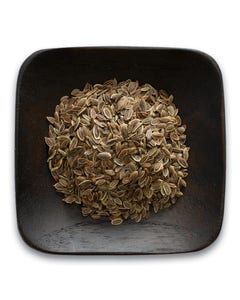 A wooden bowl filled with dried dill seeds on a white background.