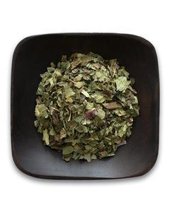 A black bowl filled with dried herbs on a white background.