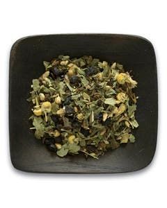 A black bowl filled with a variety of herbs and leaves.