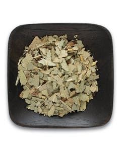 A wooden bowl filled with dried eucalyptus leaves on a white background.