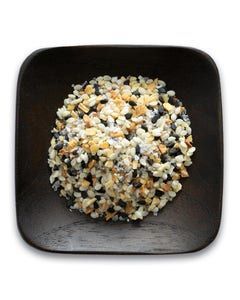 A wooden bowl filled with a mixture of nuts and seeds.