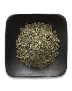 A black bowl filled with dried herbs on a white background.