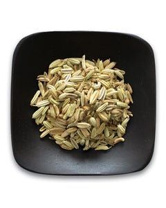 A black square plate topped with a pile of fennel seeds.
