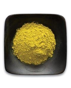 A black bowl filled with yellow powder on a white background.