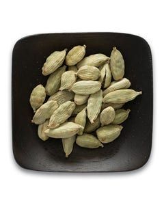 A black plate topped with cardamom seeds on a white background.
