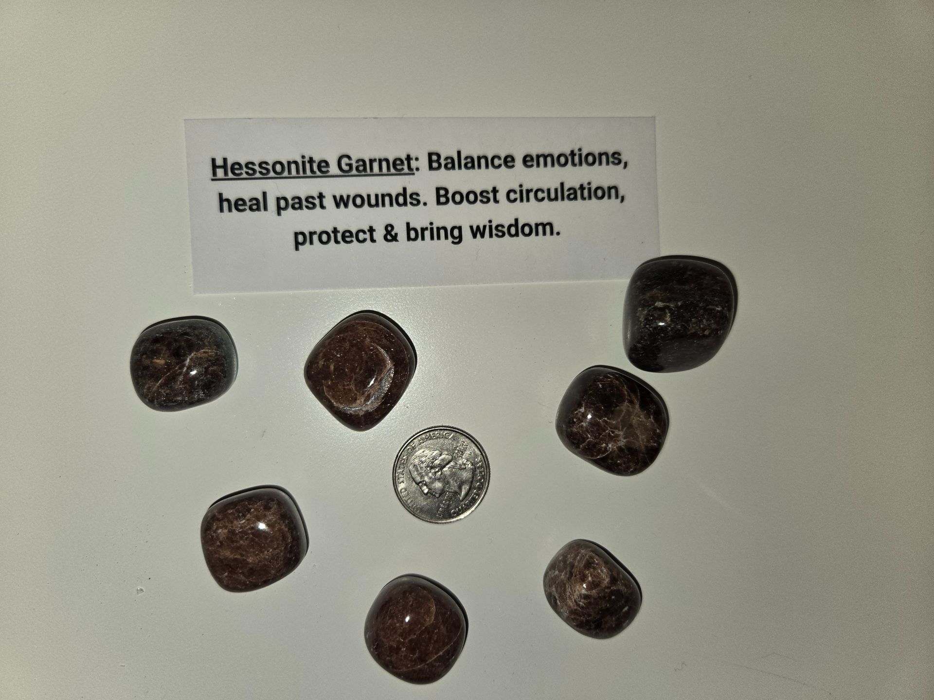 A group of stones with a card that says heasonite garnet balance emotions heal past wounds boost circulation protect & bring wisdom
