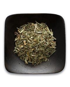 A black bowl filled with dried herbs on a white background.