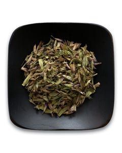 A black square bowl filled with dried herbs on a white background.