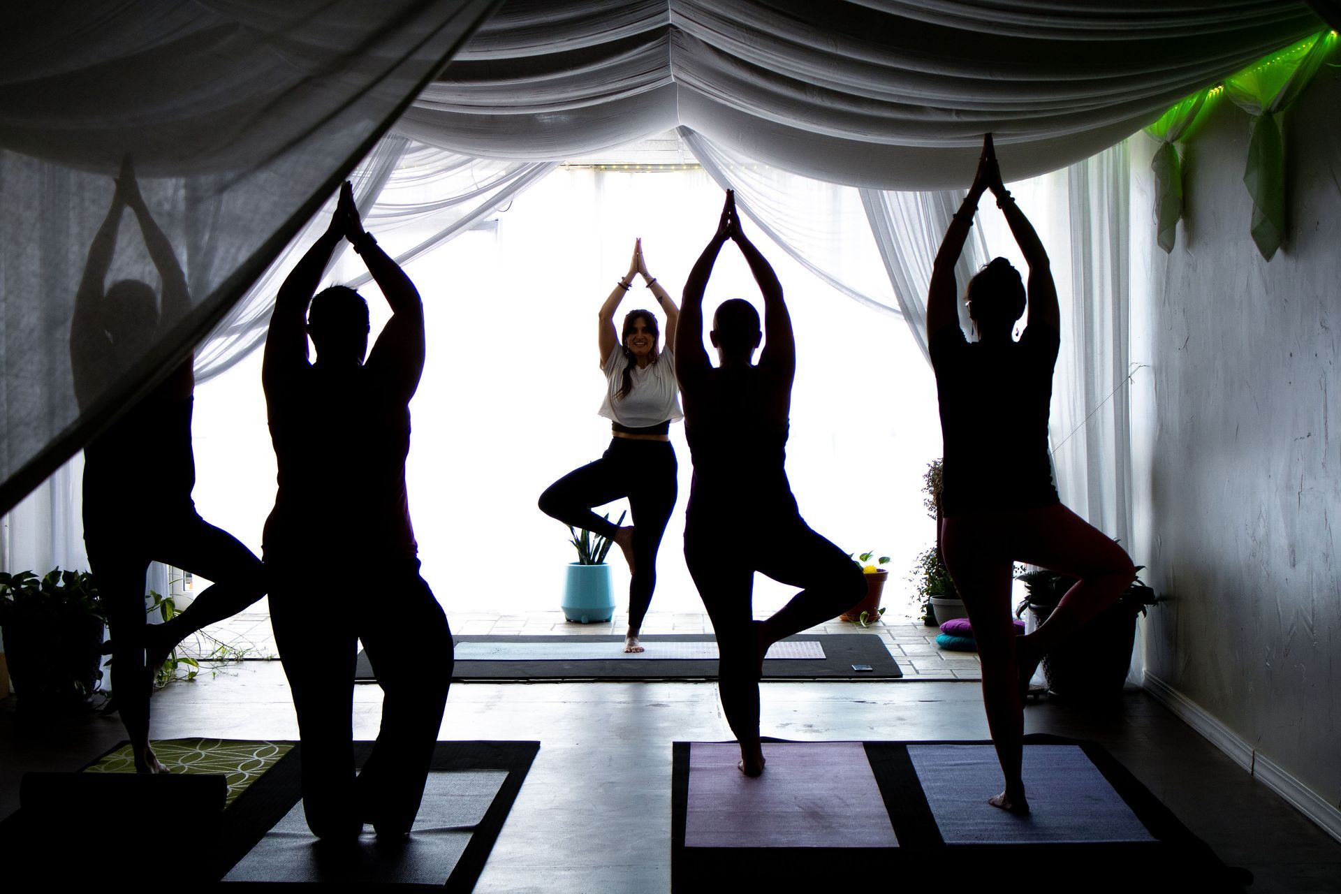 A group of people are practicing yoga in a dark room