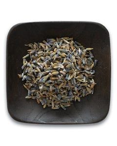 A wooden bowl filled with dried lavender flowers on a white background.
