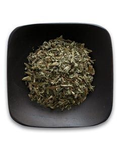 A black bowl filled with dried herbs on a white background.