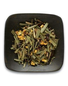 A black square plate topped with a pile of herbs and fruit.
