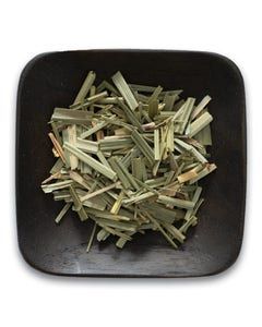 A black bowl filled with dried lemongrass leaves on a white background.