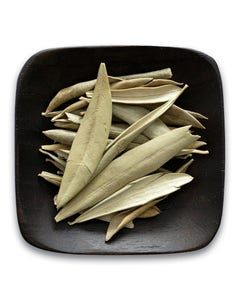 A black plate topped with dried olive leaves on a white background.