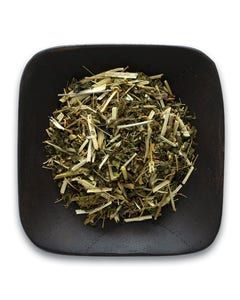 A black square plate topped with a pile of dried herbs.