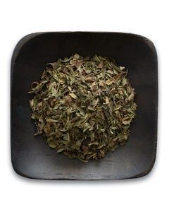 A black bowl filled with dried mint leaves on a white background.
