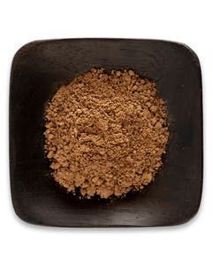 A square bowl filled with brown powder on a white background.