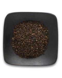 A black square bowl filled with black pepper on a white background.